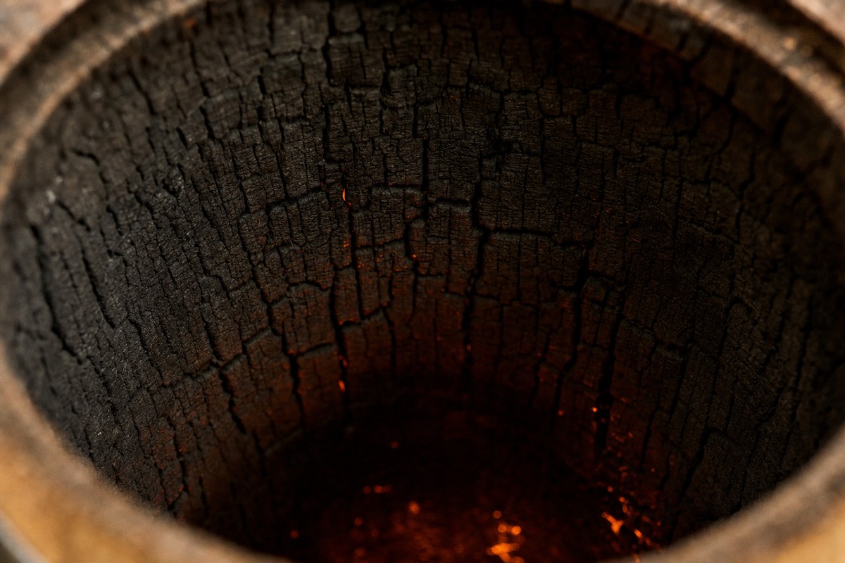 Extreme close-up looking into a freshly charred barrel interior with cracked alligator char